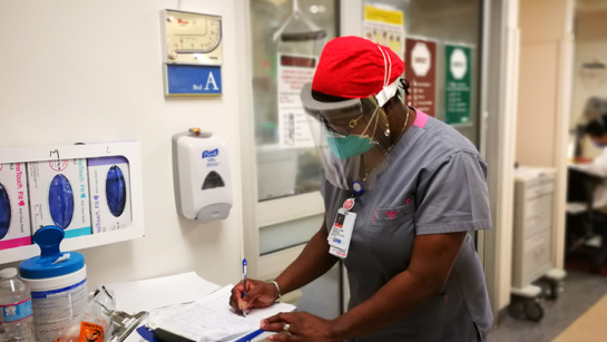 Nurse writes on clipboard