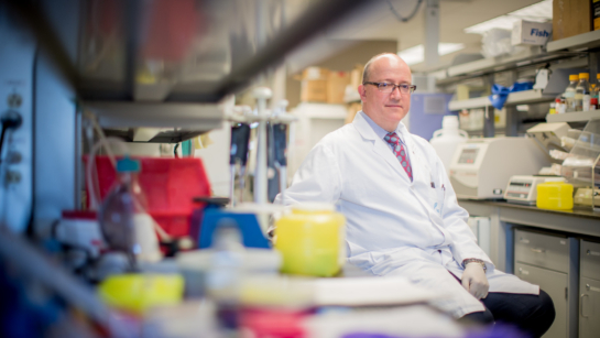 Dr. Michael Tymianski sitting in a lab