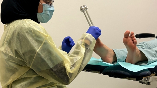 Maryam Dadgar in scrubs working on a patients foot.