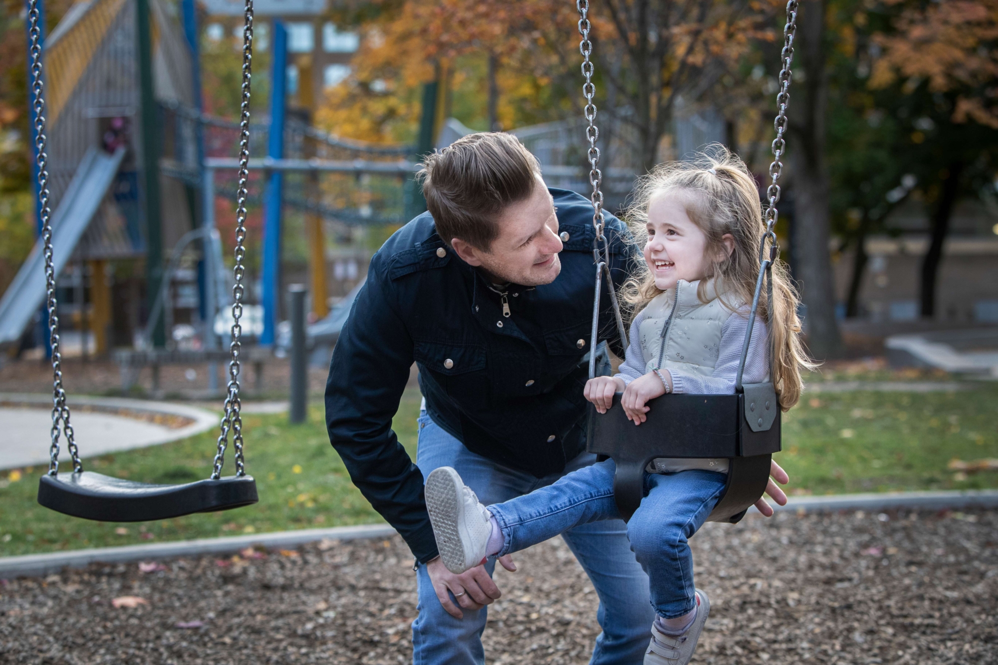 Patrick at a park with his daughter on a swing