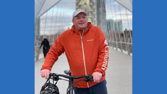 Adam Hoerdt on a bridge walking his bicycle