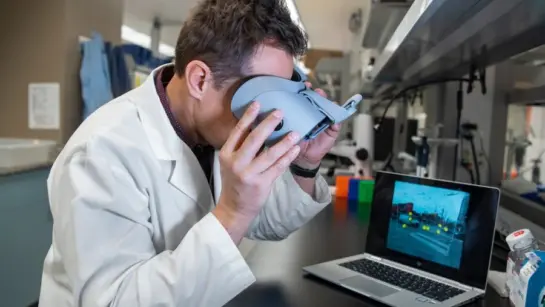 Dr. Michael Reber looking through a virtual reality headset.