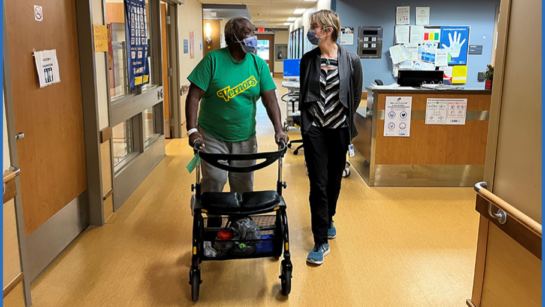 Walking with a patient in the hallway with an assisted walker