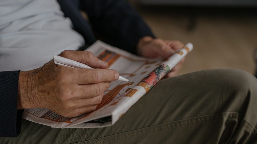 A senior filling out a crossword puzzle