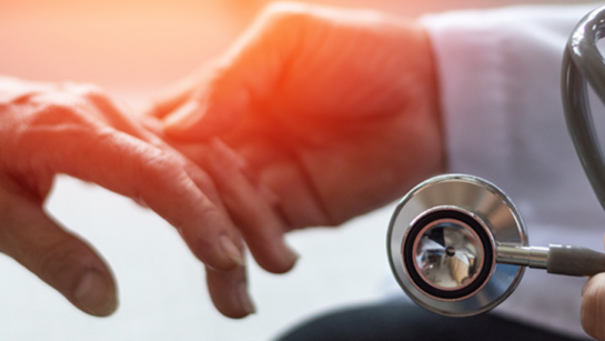 A doctor holding a patient's hand.