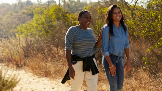 A couple go out for a hike together in the sun.