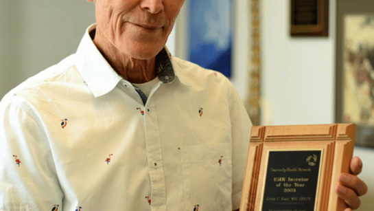 Dr. Kevin Kain, holding the plaque he won in 2003 and still keeps on the wall of his office at UHN.