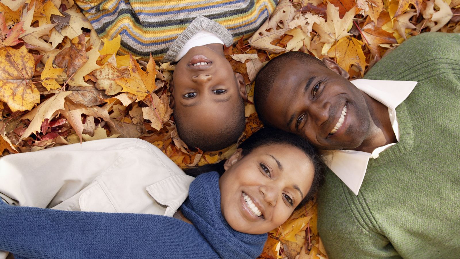 A family enjoying the fall leaves