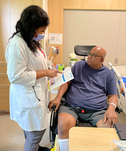 ​​Jay De Alwis, (R), an inpatient at Toronto Rehab’s Lyndhurst Centre for the Spinal Cord Rehabilitation program, with Carol McAnuff, a clinical nurse specialist, discussing Jay's pressure wound treatment. (Photo: UHN)