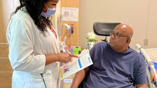 ​​Jay De Alwis, (R), an inpatient at Toronto Rehab’s Lyndhurst Centre for the Spinal Cord Rehabilitation program, with Carol McAnuff, a clinical nurse specialist, discussing Jay's pressure wound treatment.