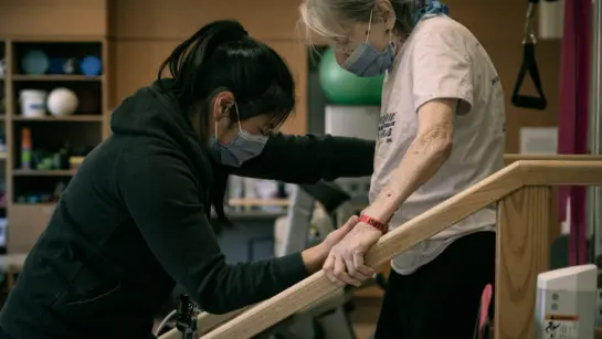 A patient at Toronto Rehab working with physiotherapist Vanessa Ong on safely maneuvering stairs.