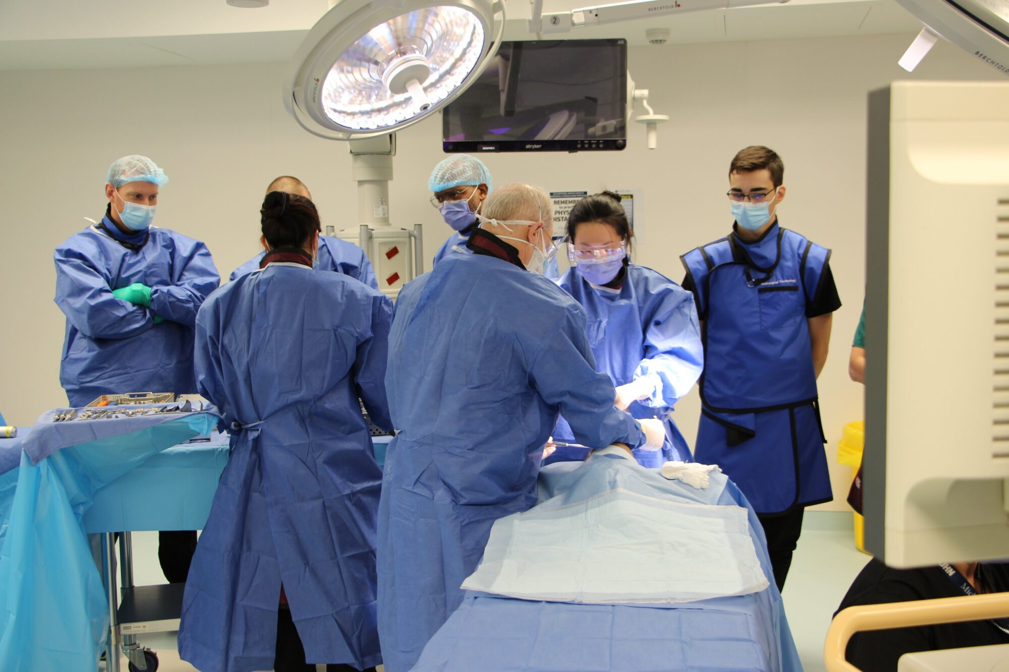 As part of their orthopedic ankle surgery course, Smith + Nephew (S&N) required X-ray imaging be taken throughout the procedure to check on the placement of the implant. (L to R), Mark Hynes, S&N, Giselle Magtoto, St. Joseph’s Health Centre, Larry Stawinski, S&N, Dwaine Jones, S&N, Dr. Harold Braden, St Joseph’​s Health Centre, Dr. Joyce Fu, St. Joseph’s Health Centre and Michener Institute radiological technology student Adam Magliozzi. (Photo: UHN)