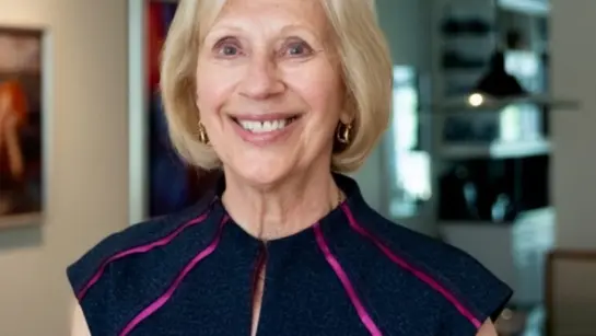 Marvi Ricker smiling in her living room while looking directly at the camera