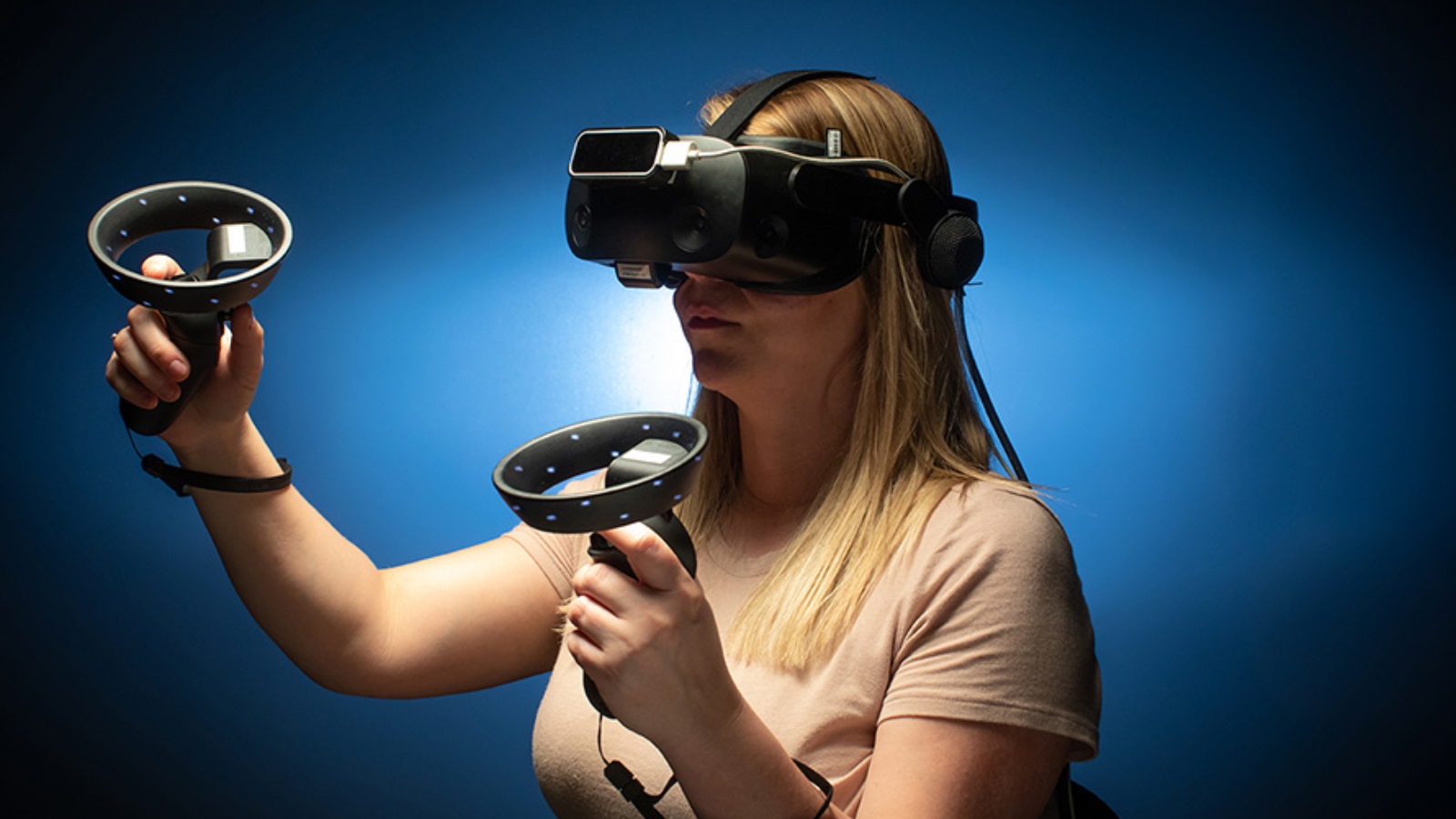 A patient with a virtual reality set on and a blue background.