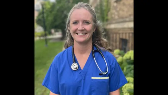 Barbara Bailey in her Nurse Practitioner scrubs from UHN while smiling outdoors in the summer