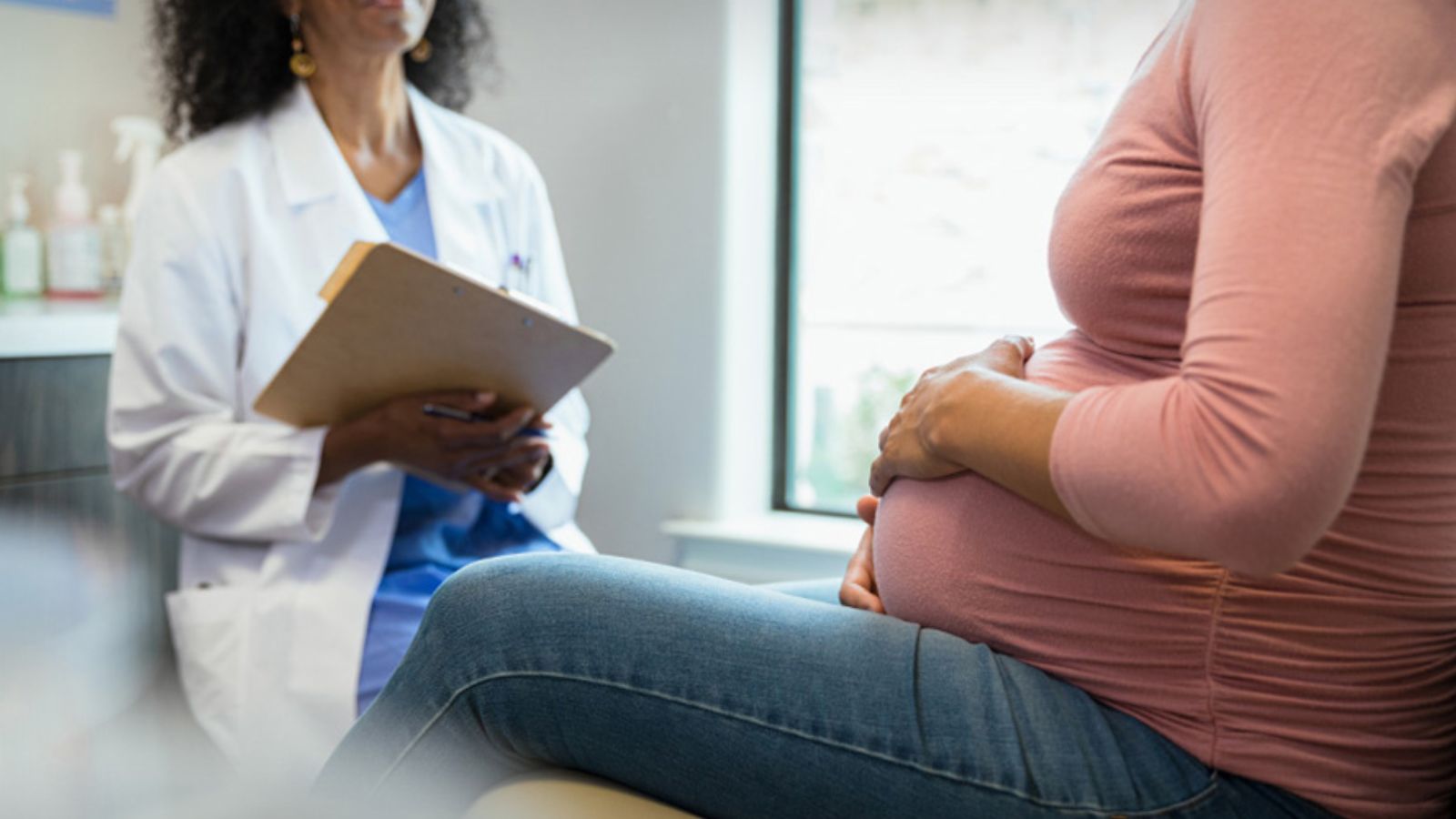 A health care professional meets with a pregnant patient.