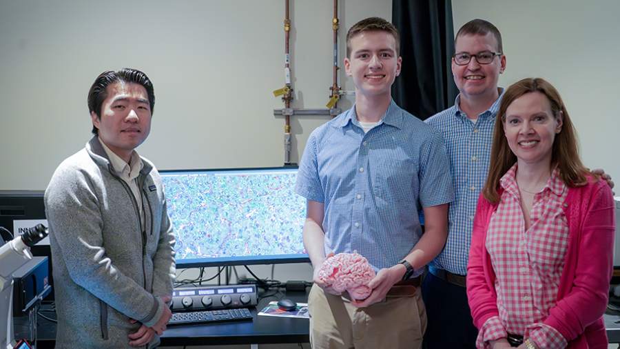 (L to R), Research Associate Dr. Xiao Tian (Tag) Yu and the Thompson family — Sawyer, Brett and Susan at UHN standing next to a computer.