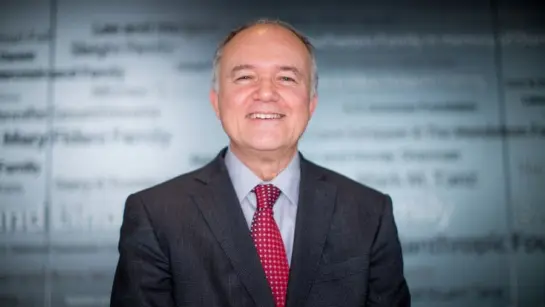 Dr. Donald Weaver, from UHN's Krembil Research Institute smiling in front of a glass window.