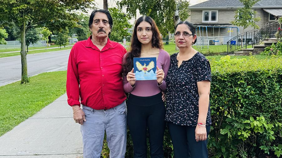 ​​​​Amanpreet Jolly, (C), with her parents, Ashok and Sukhwinder. Amanpreet holds the children's book Orta and Sparky, which she wrote after her father's experience at UHN's Peter Munk Cardiac Centre