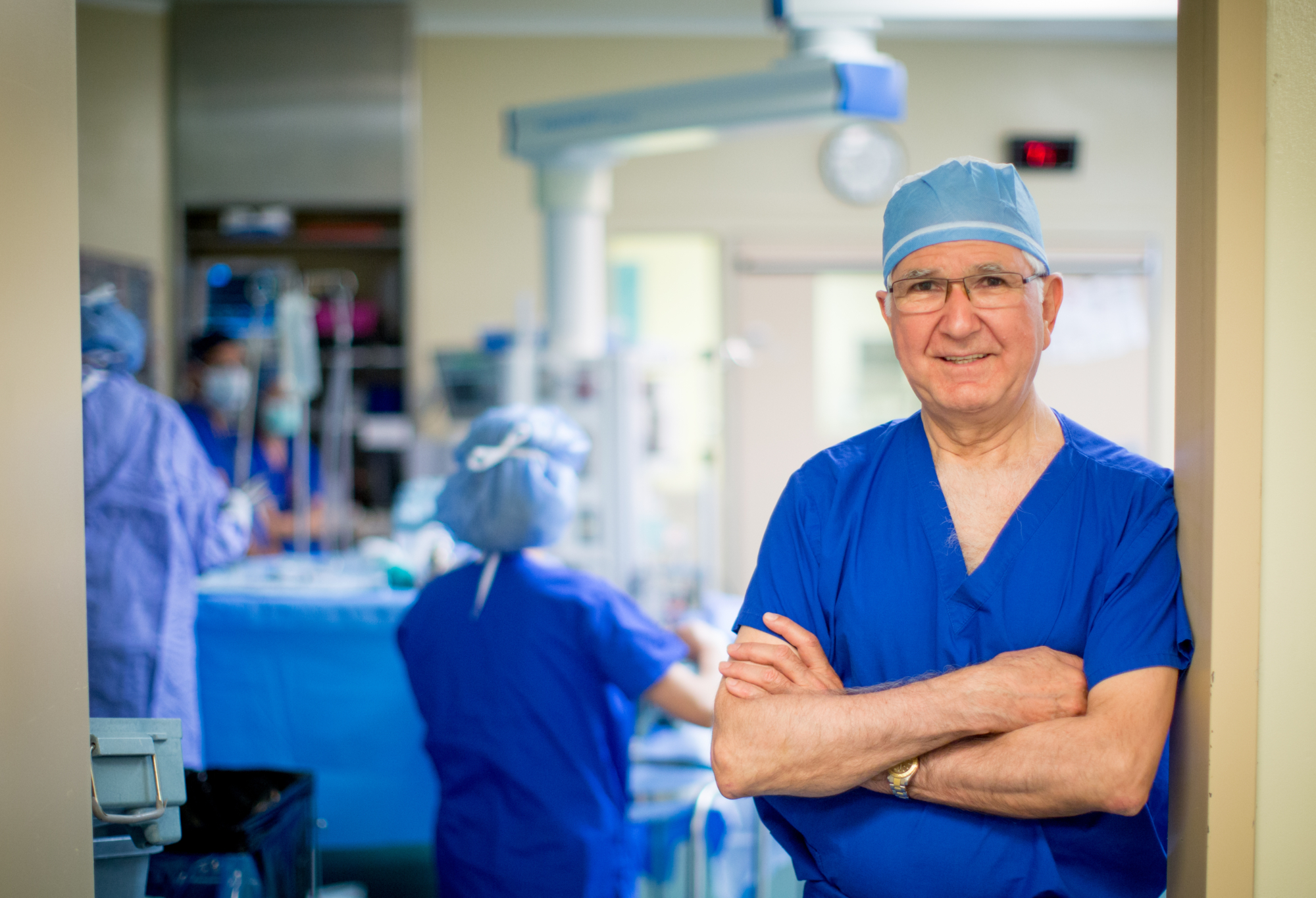 Dr. Tirone David smiling in an OR wearing scrubs