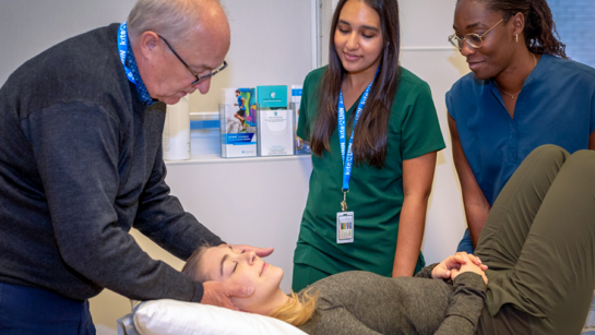 ​​Dr. Ted Crowther, (L), Director of Clinical Education & Patient Care at the Canadian Memorial Chiropractic College, demonstrates the proper technique for students.