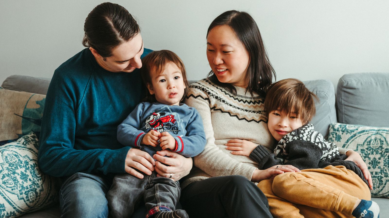 Lori Chen with her family smiling on a couch.