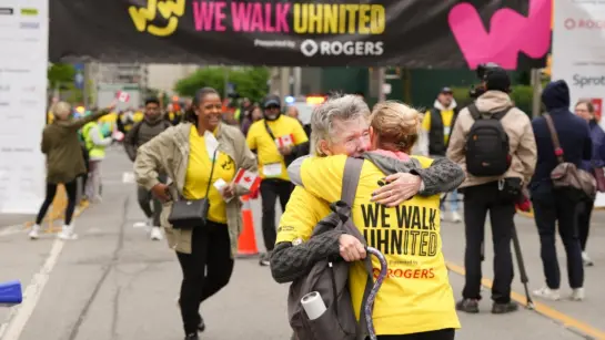 Participants hug at the finish line for We Walk UHNITED