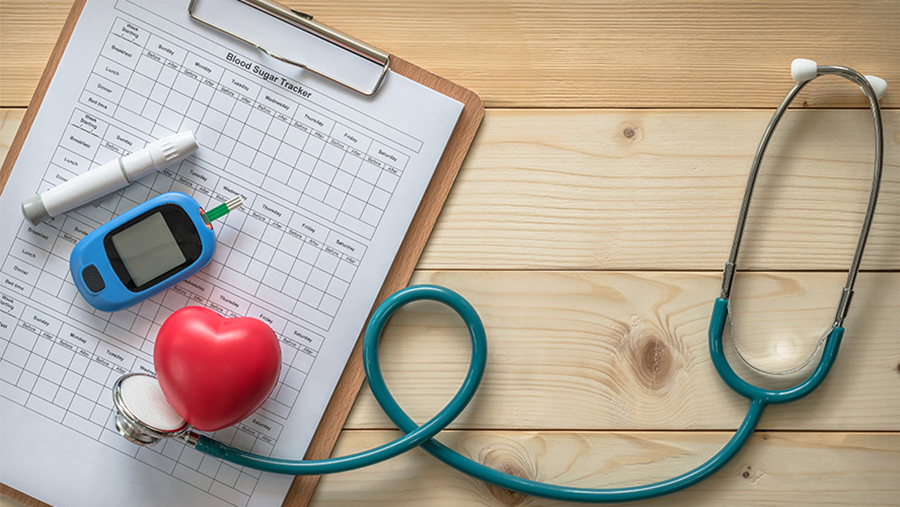 Diabetes tools on a wooden table along with a blood sugar chart