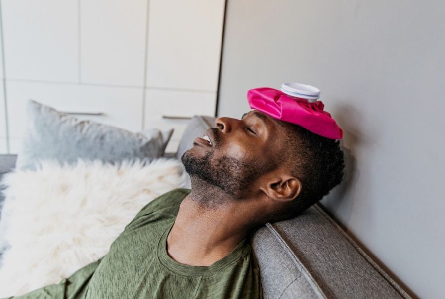 A person with an ice pack on their head to combat a migraine.