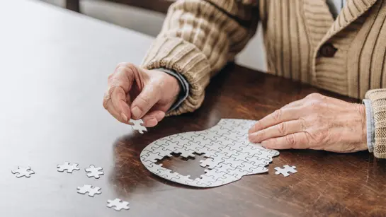 A person completing a puzzle of the human brain.