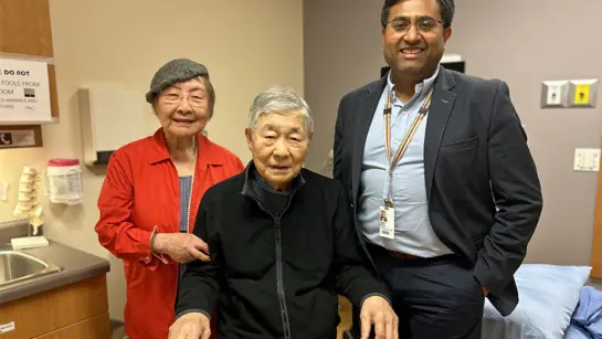 Mike Lee at Toronto Rehab in a patient room with his doctor and wife.