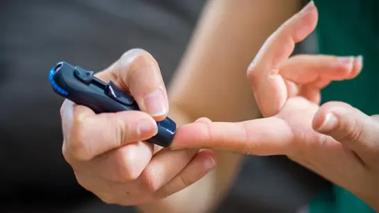 A person taking a blood sample for type 1 diabetes
