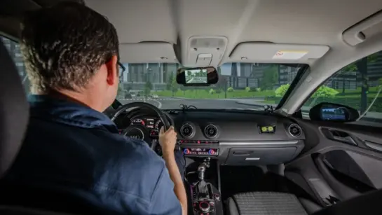 A person behind the wheel of a car in a simulator