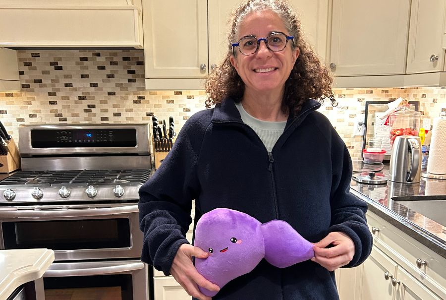 Helene holding a plush toy of her liver.