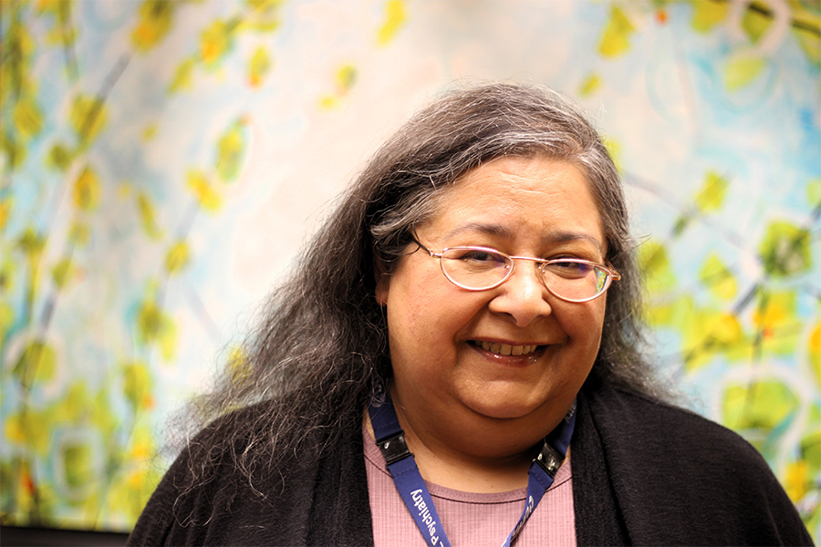 Dr. Carla Garcia smiling with a mural in the background.