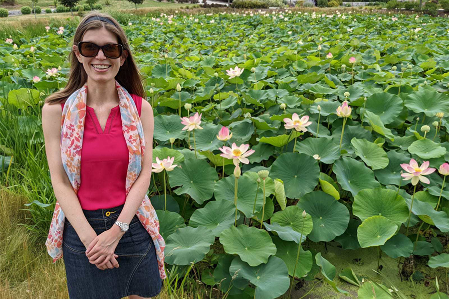 Stephanie MacAlpine standing in a field with flowers.