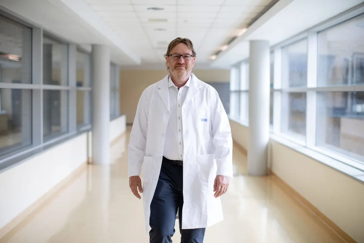 Dr. Gary Lewis at UHN walking in a bright hallway