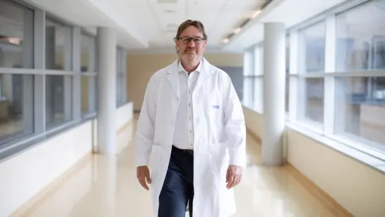 Dr. Gary Lewis at UHN walking in a bright hallway