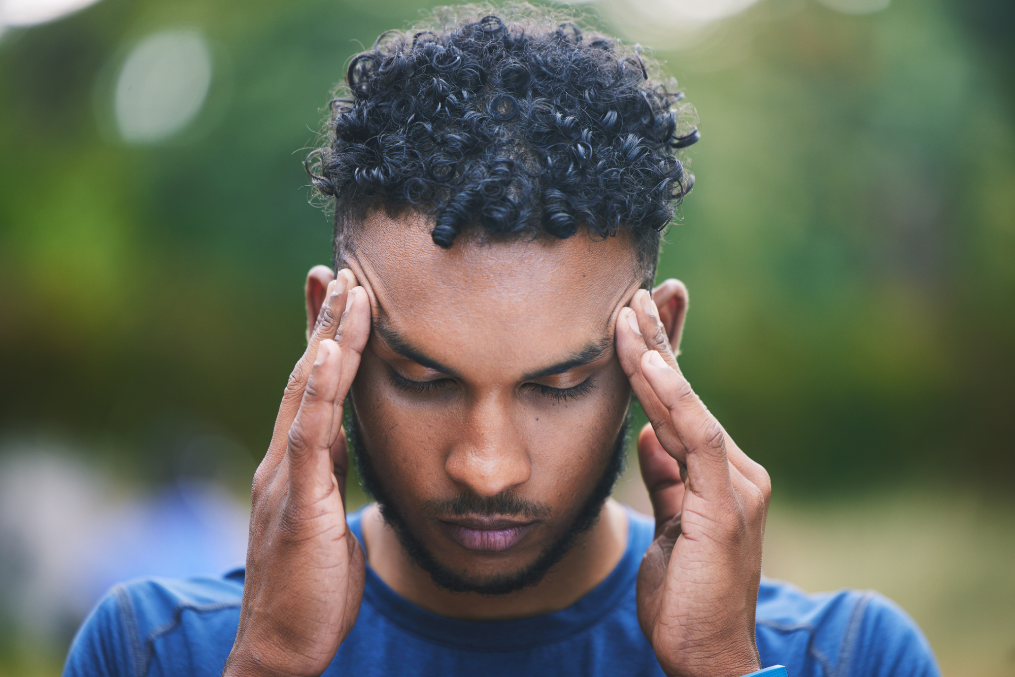 A person holding their head because of a concussion.