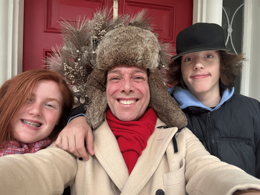 Scott Wilson and his family outside their front door with winter gear on.