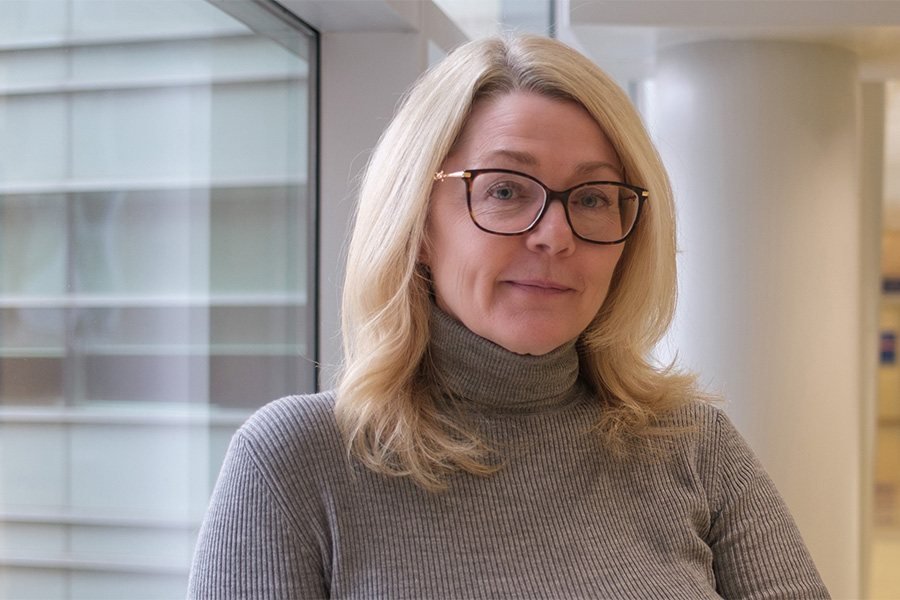 Suzanne Phillips, Program Manager, NEDIC standing in front of a window.