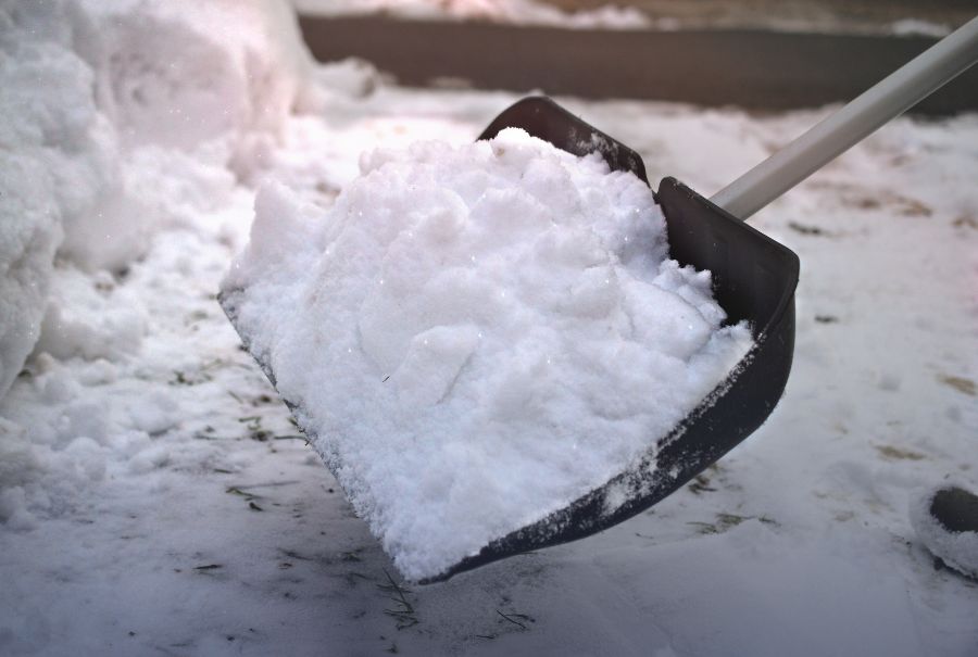 A winter shovel with snow on it.