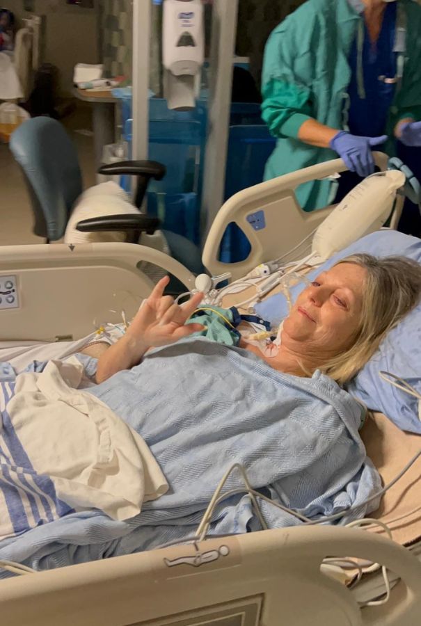 Rita laying on a hospital bed on her way to the operating room.
