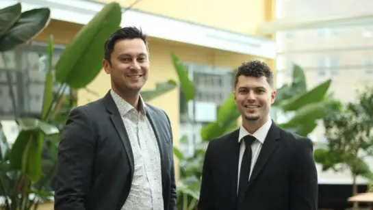 Daniel Sibley and Santa Mina at Toronto General Hospital in the atrium next to plants.
