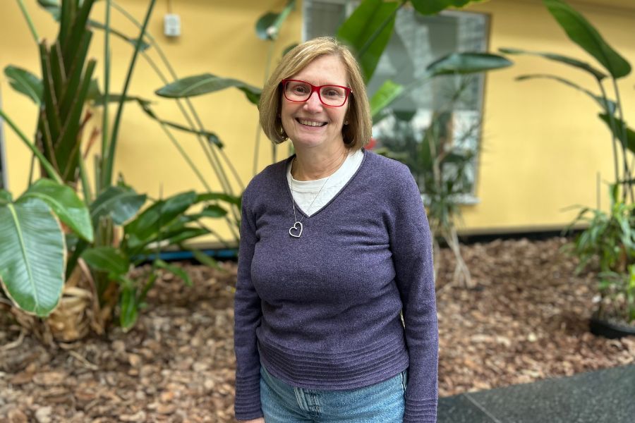 Paula Vanderpluym standing next to plants at UHN's Toronto General Hospital.