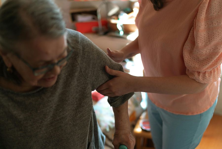 A daughter helping her mother get up.