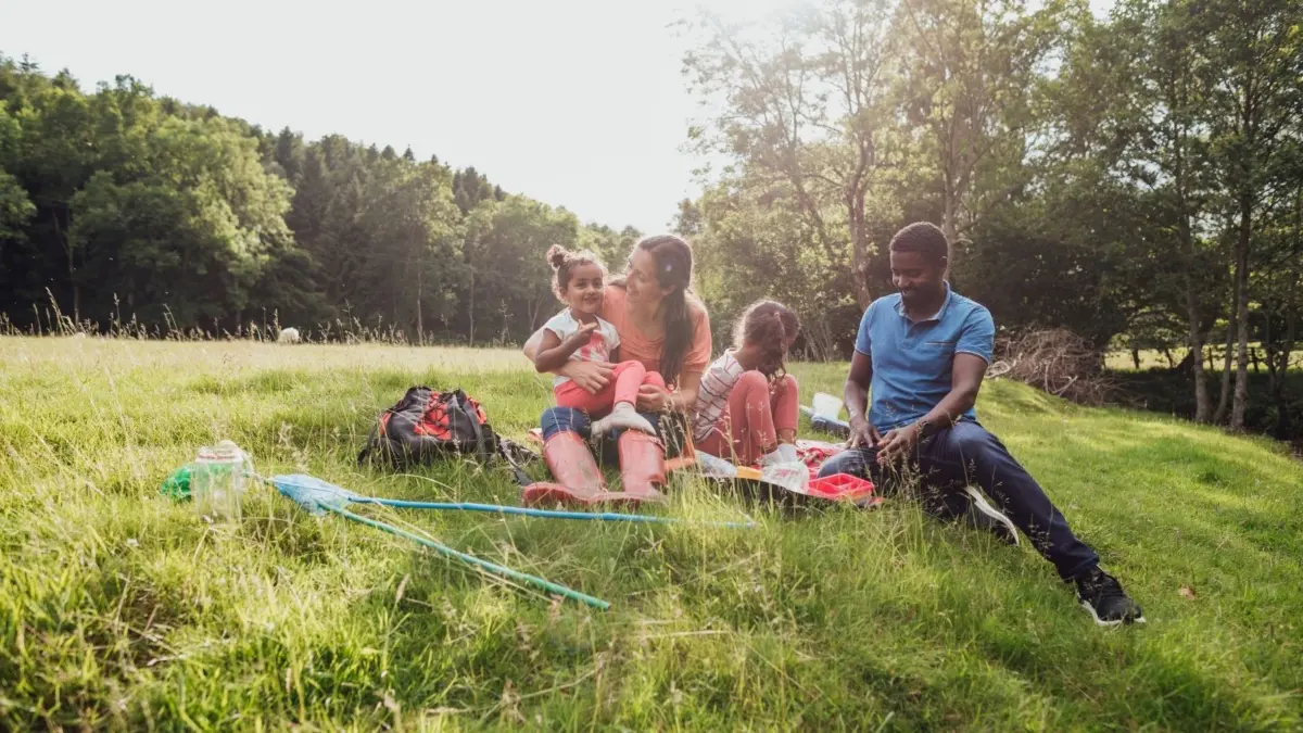 A family enjoying the outdoors with a packed lunch and the sun shining.