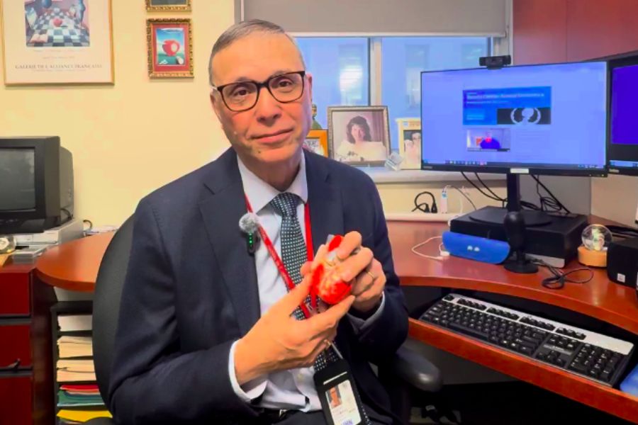 Dr. Robert James (RJ) Cusimano holding a model of a heart while in his office.