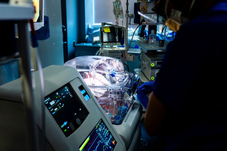 The ex vivo lung perfusion technology with lungs in a clear chamber. The system is operating in a surgical room with other machines in the background.