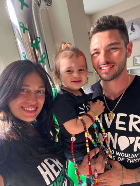 Bianca, next to Joseph holding Camilla after the transplant with organ donation stickers and t-shirts on.
